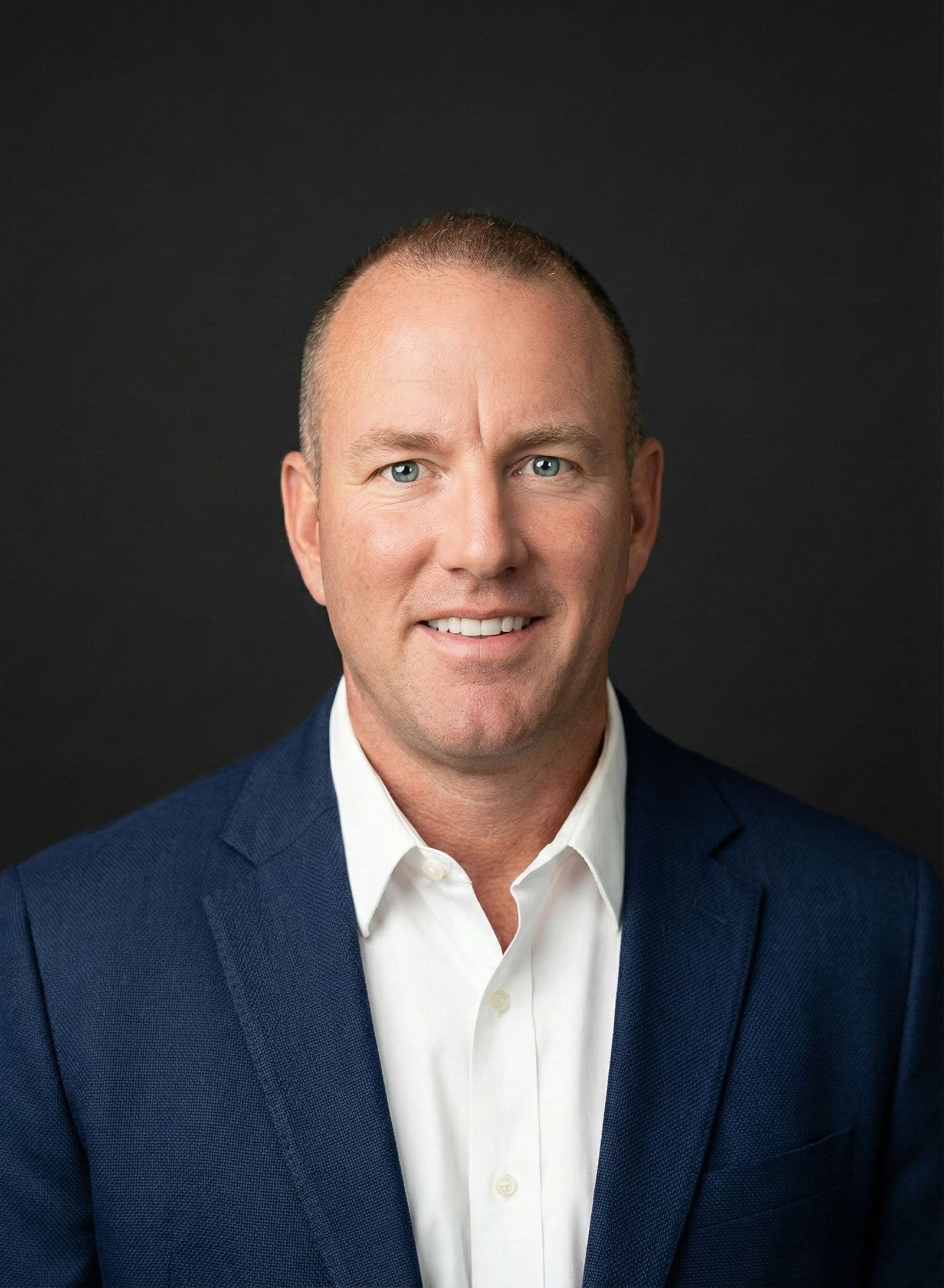 Gregg Costin in a navy jacket and white shirt